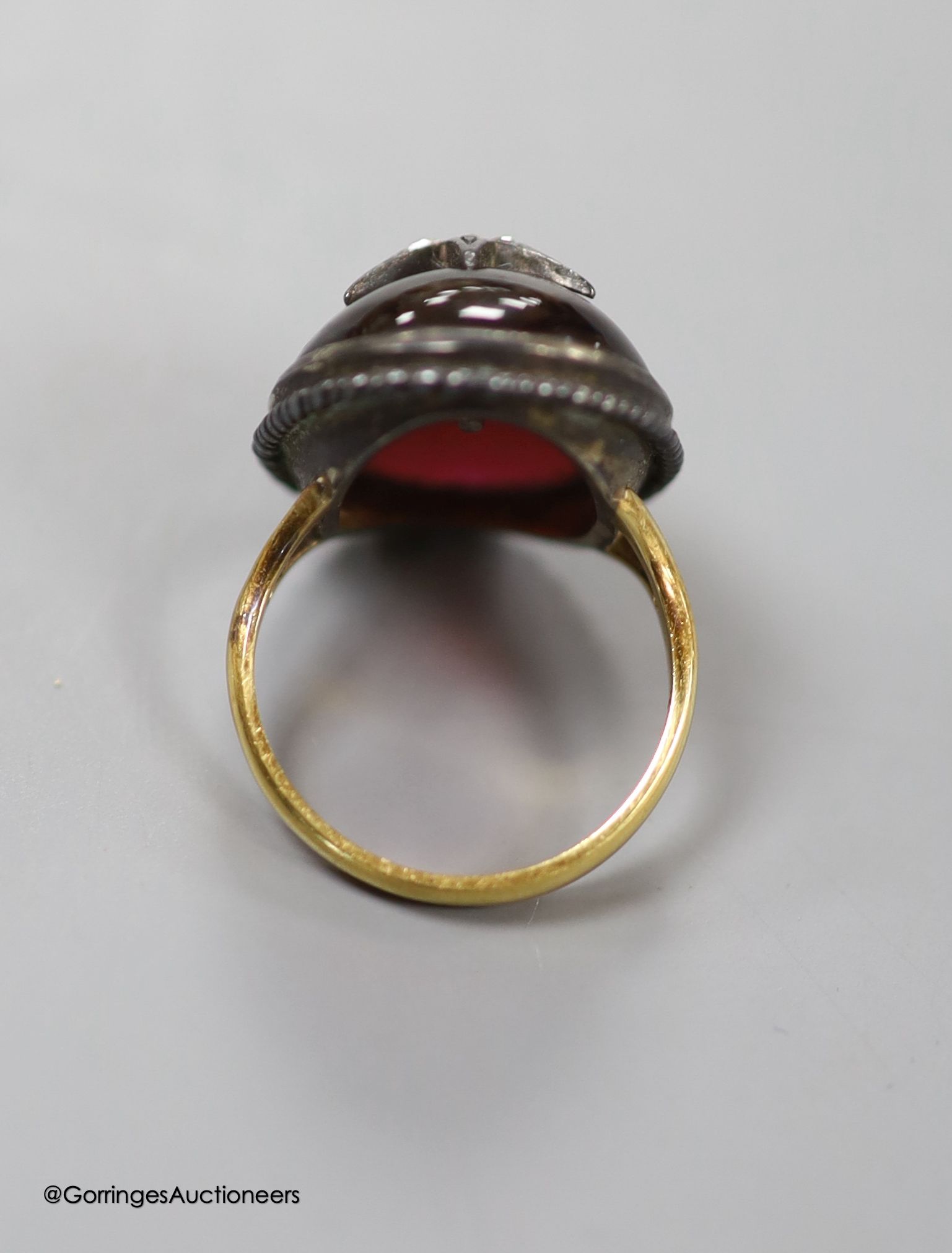 A 19th century yellow and white metal, oval cabochon garnet and rose cut diamond set ring, with central star motif, size L/M, gross 7.9 grams.